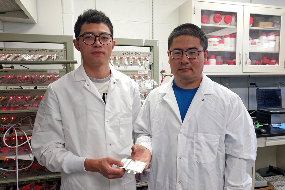 Co-first-authors Long Chen (L) and Xiulin Fan (R) hold their newly-created rechargeable battery made with fluorine, a long-lasting and safe combination.