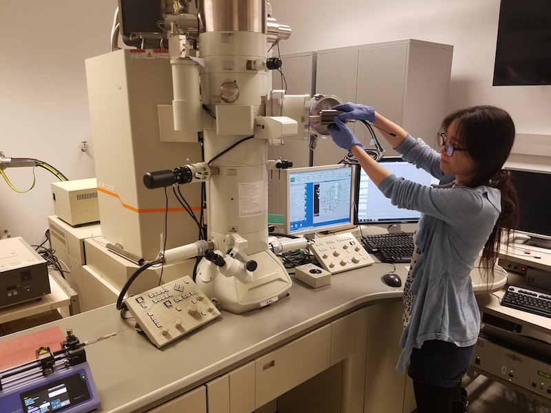 Mei Wang adjusts a microsope in the Woehl Group lab.