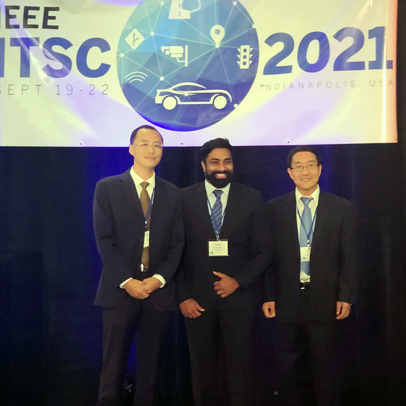 The ITSC 2021 Best Student Paper Award ceremony in Indianapolis in September. At left is Lingxi Li, Program Chair of ITSC 2021 and Professor of Electrical and Computer Engineering at Purdue University. Nilesh Suriyarachchi, the paper’s first author, is in the center. At right is Yaobin Chen, General Chair of ITSC 2021 and Director of TASI, Professor of Electrical and Computer Engineering, and Chancellor's Professor at Purdue University.