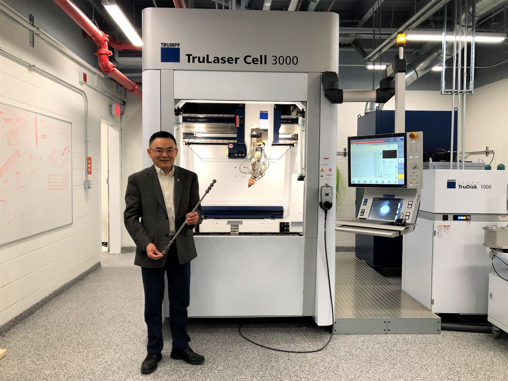 Zhao in front of a 3D printer in his lab at UMD.