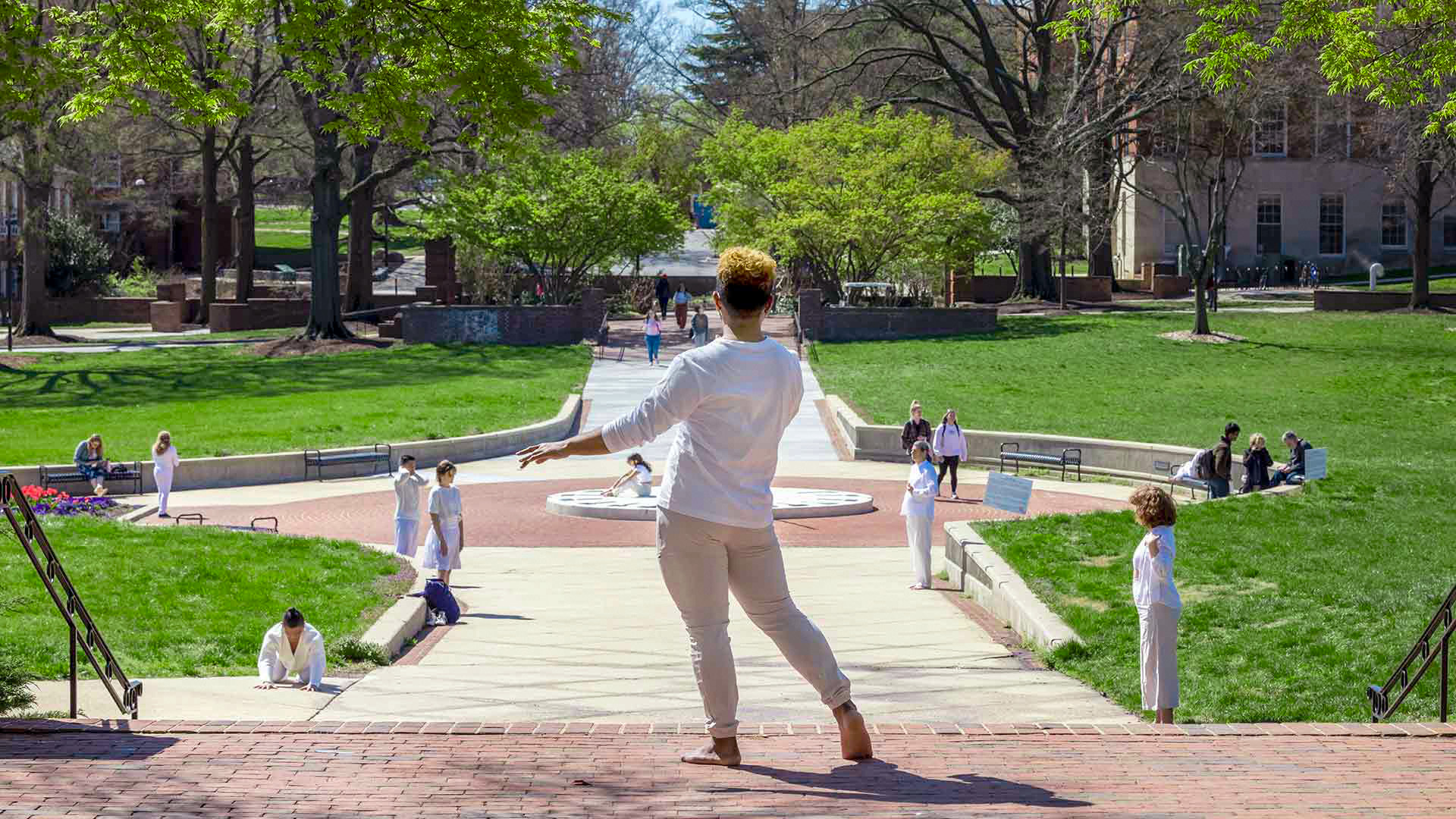Human sculptures, wearing white, pose on McKeldin Mall on Friday as part of “On Display,” an art installation that celebrates diverse body types. Photo by Stephanie S. Cordle