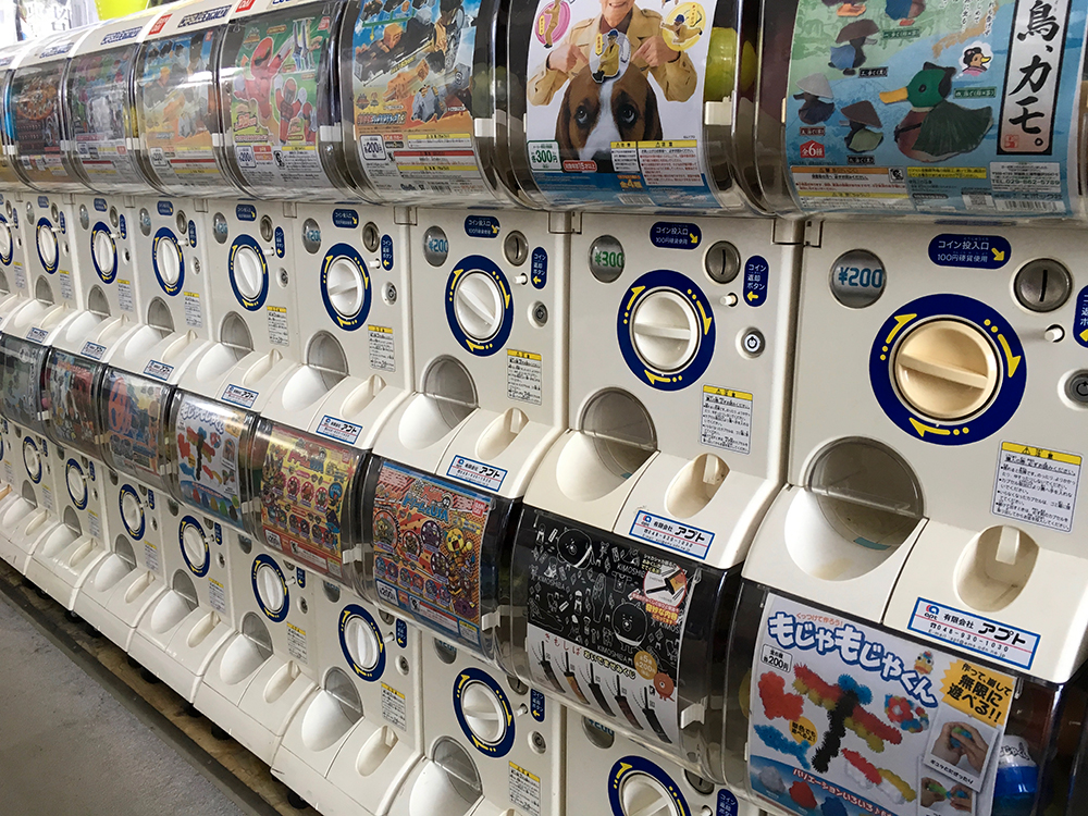 A row of gachapon machines in Tokyo. A customer chooses a vending machine displaying a type of toy they'd like, based on the machine's front menu. But they do not know which of several toys they will receive. Photo by Rebecca Copeland, ISR.
