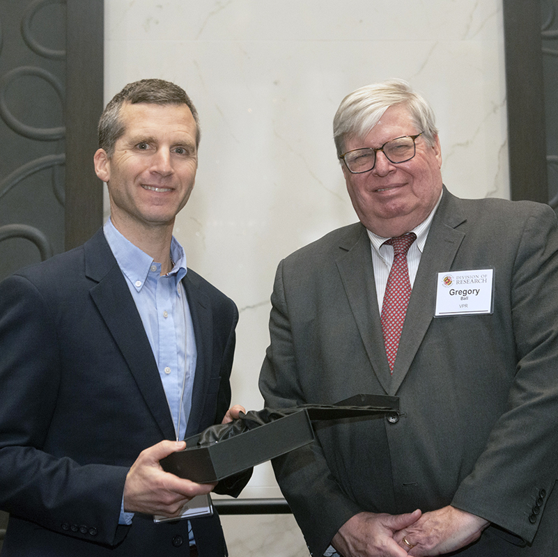 Derek Paley, left, receives his award from Vice President for Research Greg Ball. Photo courtesy Division of Research.