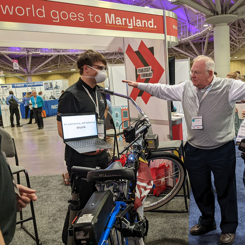 Mechanical engineering students demonstrating their award-winning, self-balancing electric bicycle during the 2022 ASEE conference.