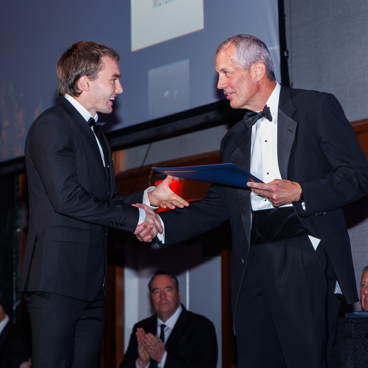 Dylan Hurlock receiving his award certificate from Wings Club President, Tom Gentile, during the October gala event.