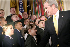President George W. Bush congratulates newly commissioned member, Leslie Woll, undergraduate aerospace engineering student, of the Joint Reserve Officer Training Corps - White House photo by Eric Draper 