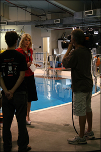 Fox 5 reporter Holly Morris interviews the Robotics@Maryland team inside the Neutral Buoyancy Research Facility.