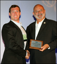 Matt Mosteller receives the award from INCOSE President John Thomas.