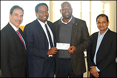 Alumnus Dunstan Macauley '02, (second from the right), presents the check in support of the ASHRAE Scholarship Fund to Dean Darryll Pines, Farvardin Professor & Dean (second from the left), with Professors Michael Ohadi (left), and B. Balachandran, Minta Martin Professor & Chair of Mechanical Engineering (right).