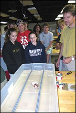 Ken Kiger (right) leads the steam-powered boat races for Discovering Engineering summer camp students.