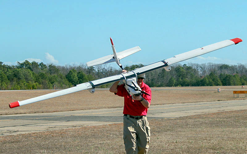 Jim Alexander from UMD's UAS Test Site carries a Talon 120 to the operation launch site.