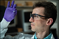 Rice University graduate student Sean Bittner holds a sample of a 3D-printed scaffold that may someday help heal osteochondral injuries of the kind often suffered by athletes. The material mimics the gradient structure of cartilage to bone found at the end of long bones. Photo by Jeff Fitlow