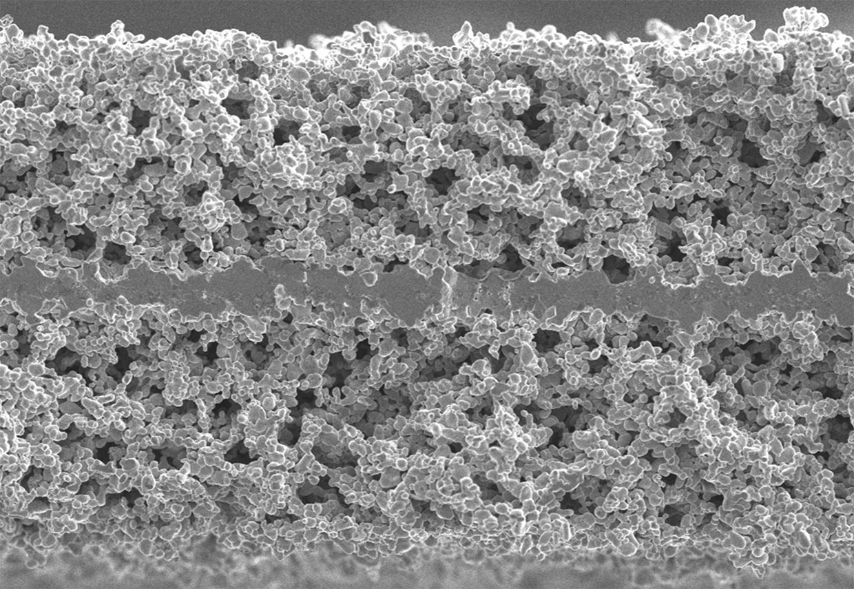 This electron microscope photo shows a thin, dense layer of a ceramic electrolyte that goes between two porous layers in a solid-state battery made by Ion Storage Systems.