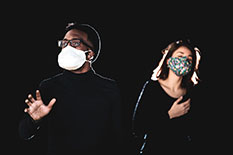Two opera singers perform with masks