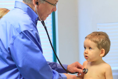 Baby boy's doctor's appointment, pediatrician checks his heart with a stethoscope