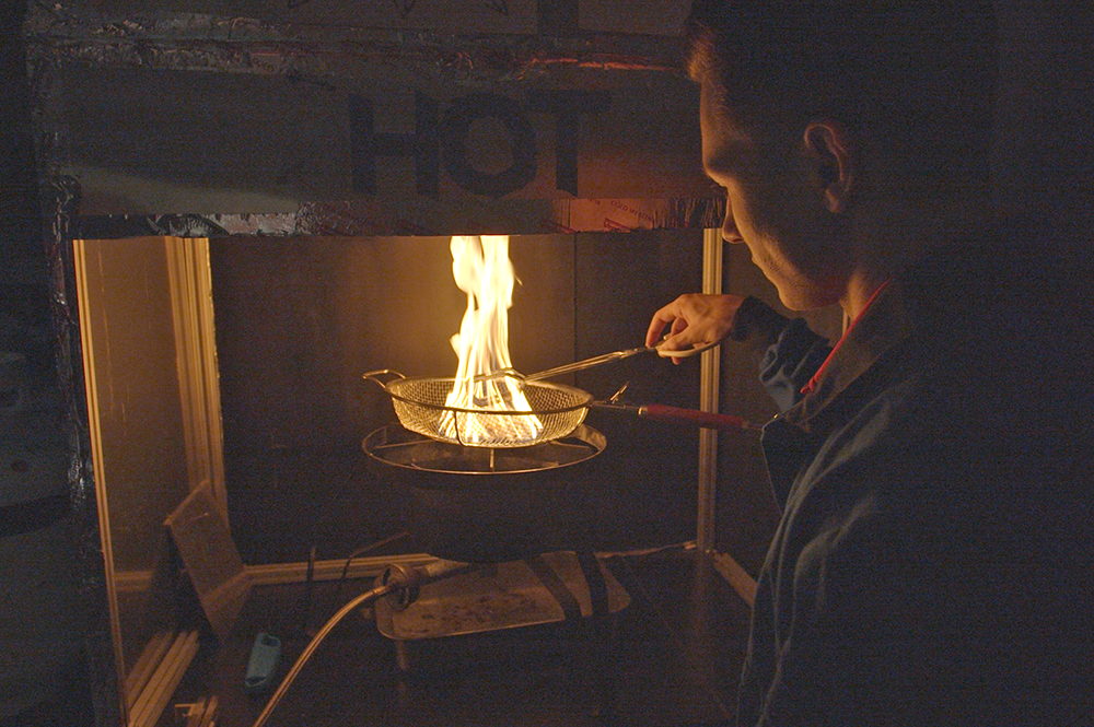 Graduate student Joe Alascio tends to a pile of burning embers called firebrands.