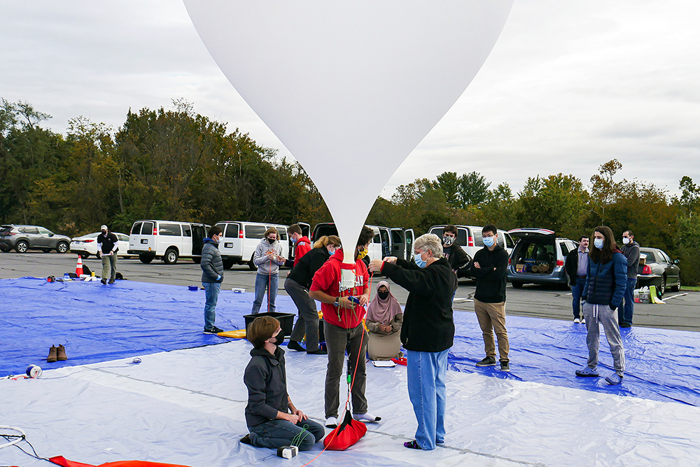 
Students in UMD's Balloon Payload Program, advised by aerospace engineering Senior Lecturer Mary Bowden (center) prepare last month to launch a weather balloon that will climb into the upper atmosphere—the program's 104th launch in 18 years.Photo by Madelaine Lebetkin.

