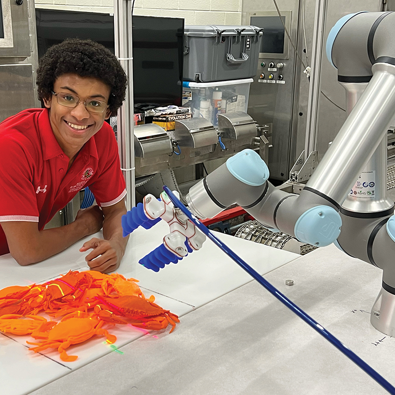 A UMD student using a robotic manipulator arm