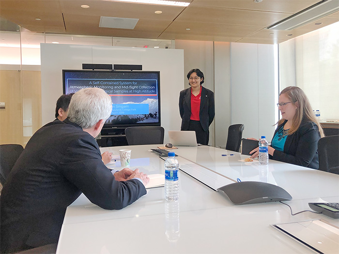 Caitlyn Singam (red shirt) presents her research to members of the Fischell Institute