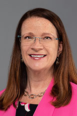 Headshot of Jennifer Schwartz wearing glasses and a pink blazer