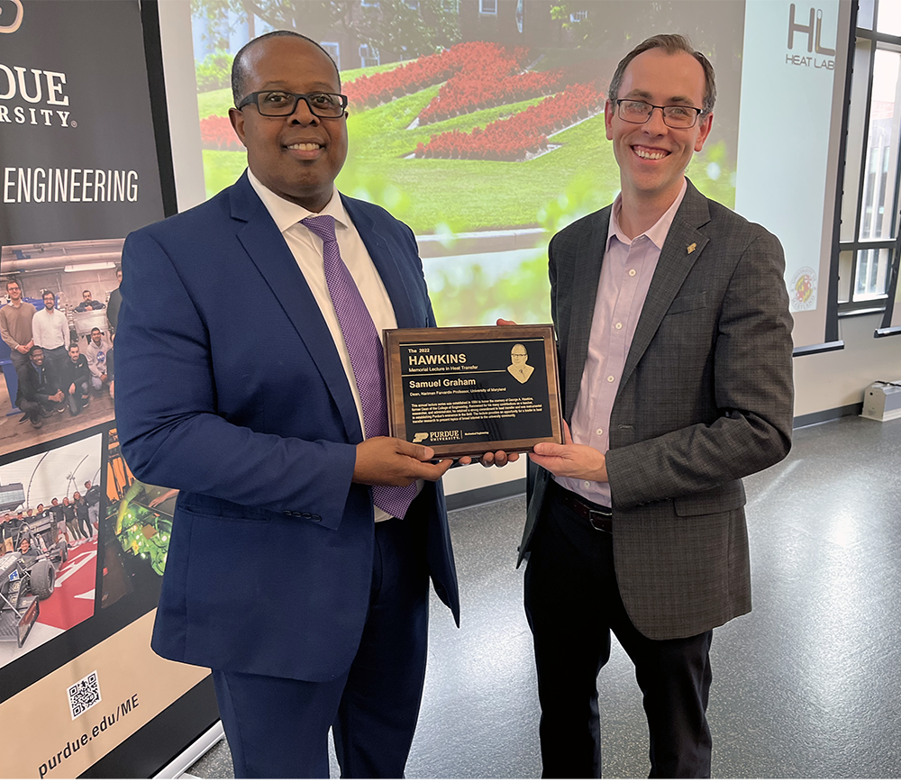 Maryland Engineering's Dean Samuel Graham, Jr. (left) and Justin A. Weibel, associate professor of mechanical engineering, Purdue University, pose with a plaque commemoratint the 2022 Hawkins Memorial Lecture.