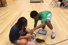 Two children from the Lego Robotics Program working on their project