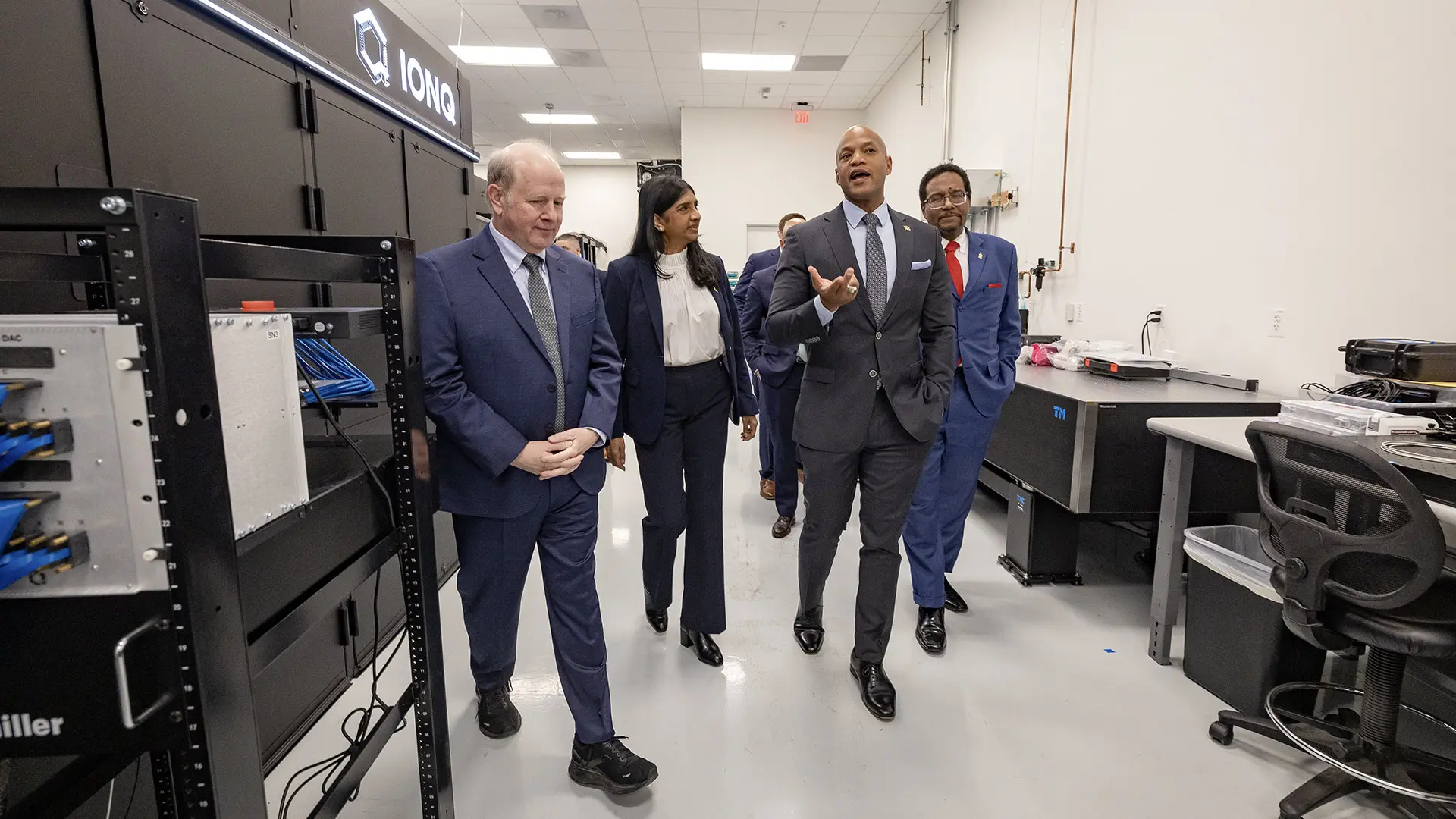 From left, a group including IonQ President and CEO Peter Chapman, Maryland Lt. Gov. Aruna Miller, Gov. Wes Moore and UMD President Darryll J. Pines tour the quantum computing company's headquarters in the university's Discovery District, where each spoke at a Tuesday event heralding the launch of the $1B 