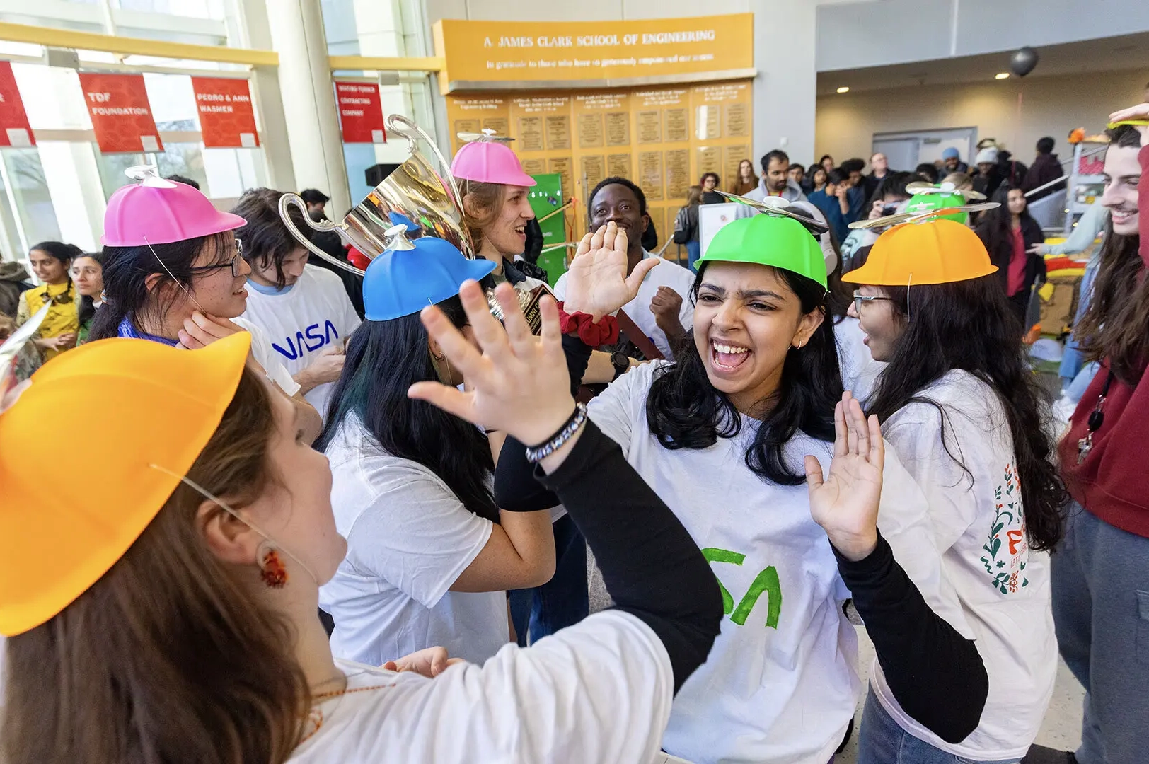 Saanchi Desai ’26 (in green hat) high-fives Elizabeth Ivanova ’28 (left) in the Jeong H. Kim Engineering Building atrium after they and teammates from the Department of Aerospace Engineering won the 14th annual Alumni Cup competition.