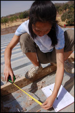 Civil engineering sophomore Kana Matsui measures dimensions for the installation of a solar panel array.  Photo by Elisabeth Smela.