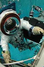 A diver works on a model of the Hubble Telescope, assisted by the Ranger robot.