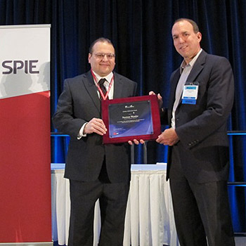 Prof. Christopher Lynch of UCLA (right) presents the  SPIE Smart Structures and Materials Lifetime Achievement Award to Prof. Norm Wereley (left) at the SPIE SS/NDE Symposium on March 12, 2013.